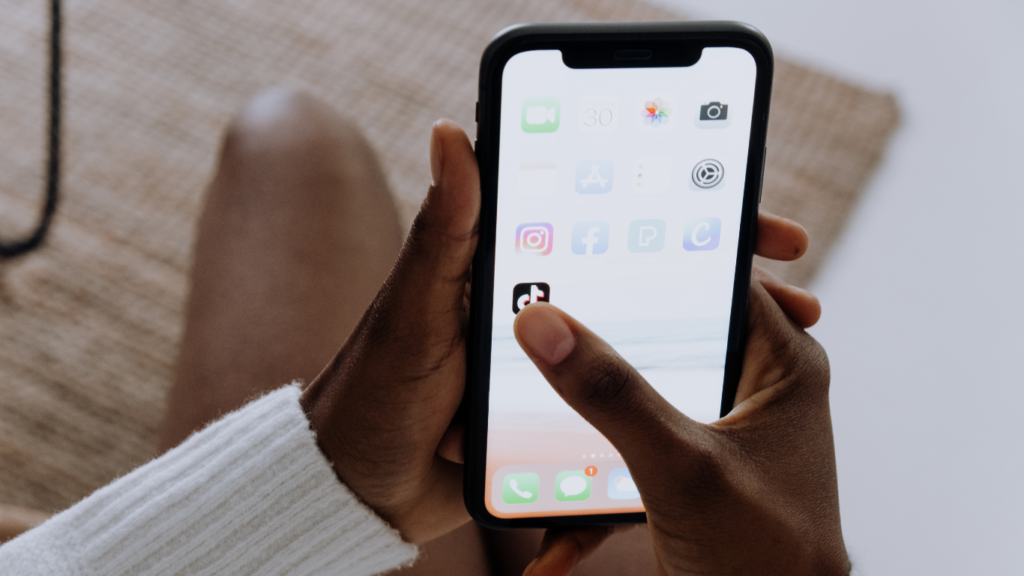 man holding phone with apps